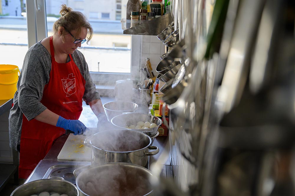 Freiwillige Mitglieder der Heilsarmee kochen für Bedürftige